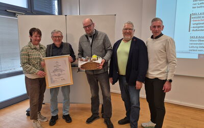 Wilfried Wahl hält seine Ehrenurkunde in den Händen und lächelt. Neben ihm stehen Obermeister Ralf Kummer-Schäfer, stellvertretender Obermeister Jörg Engelhard, Kai Bremmer und Silke Nagel.