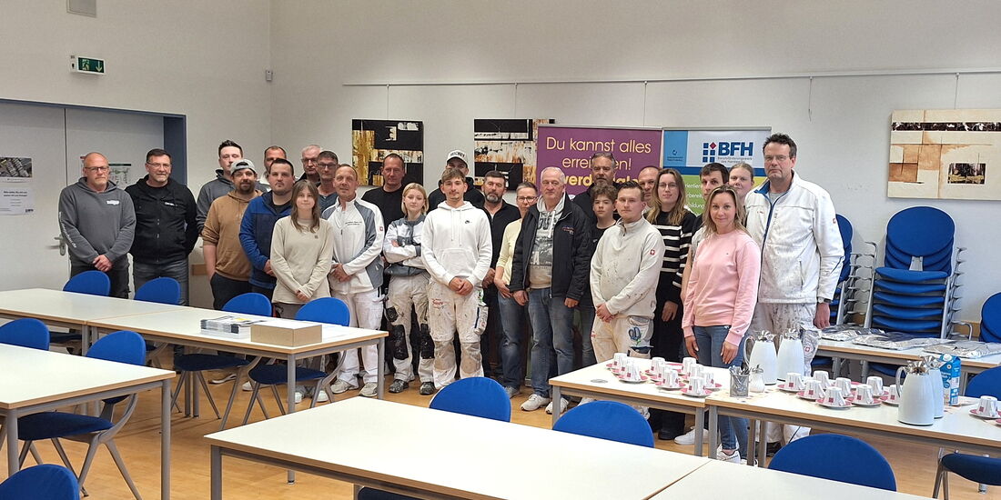 Teilnehmende stehen in Zweiherreihe im Konrad-Seibel-Raum und blicken lächelnd in die Kamera – gemeinsames Seminar zur Lehmtapete.