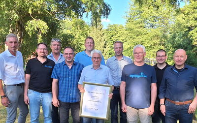 Gruppenfoto des neuen Vorstands der Metall-Innung mit Michael Ernst (Ehrenobermeister) alle stehen im Garten und lächeln.