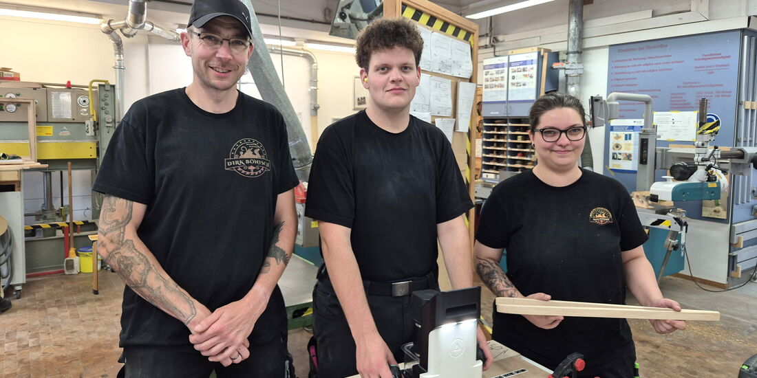 Dirk Bönisch erklärt zwei Tischler-Azubis an der Shaper, wie sie ihre Grillzangen gravieren.