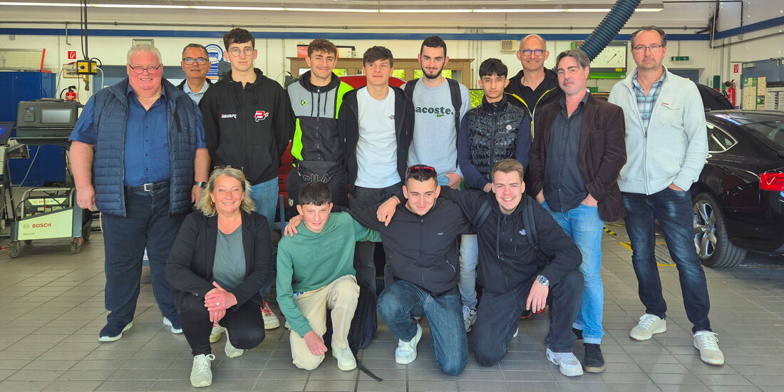 Gruppenfoto mit französischen Kfz-Azubis, ihren Betreuern und Vertretern der Kreishandwerkerschaft in der Kfz-Werkstatt im BBZ Korbach.