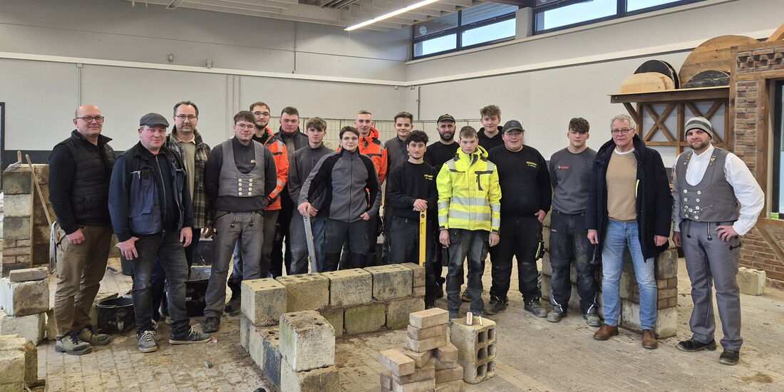 Auszubildende des Bauhandwerks mit Ausbildern im Lehrbauhof Korbach während der Grundstufenausbildung.