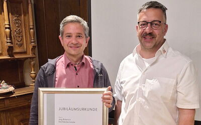Jörg Bitterlich erhält Ehrenurkunde zum 25-jährigen Meisterjubiläum – Obermeister Demmer-Koutroulis gratuliert persönlich.