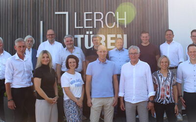 Gruppenfoto der Teilnehmenden der Mitgliederversammlung vor dem Eingang der Lerch-Türen GmbH in Rosenthal.