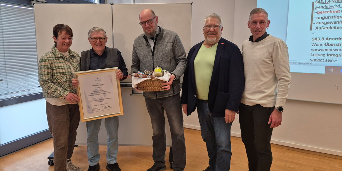 Wilfried Wahl hält seine Ehrenurkunde in den Händen und lächelt. Neben ihm stehen Obermeister Ralf Kummer-Schäfer, stellvertretender Obermeister Jörg Engelhard, Kai Bremmer und Silke Nagel.