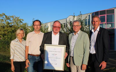 Fünf Personen bei der Übergabe der Ehrenurkunde an Guido Kalbe zum Ehrenkreishandwerksmeister.