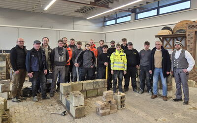 Auszubildende des Bauhandwerks mit Ausbildern im Lehrbauhof Korbach während der Grundstufenausbildung.
