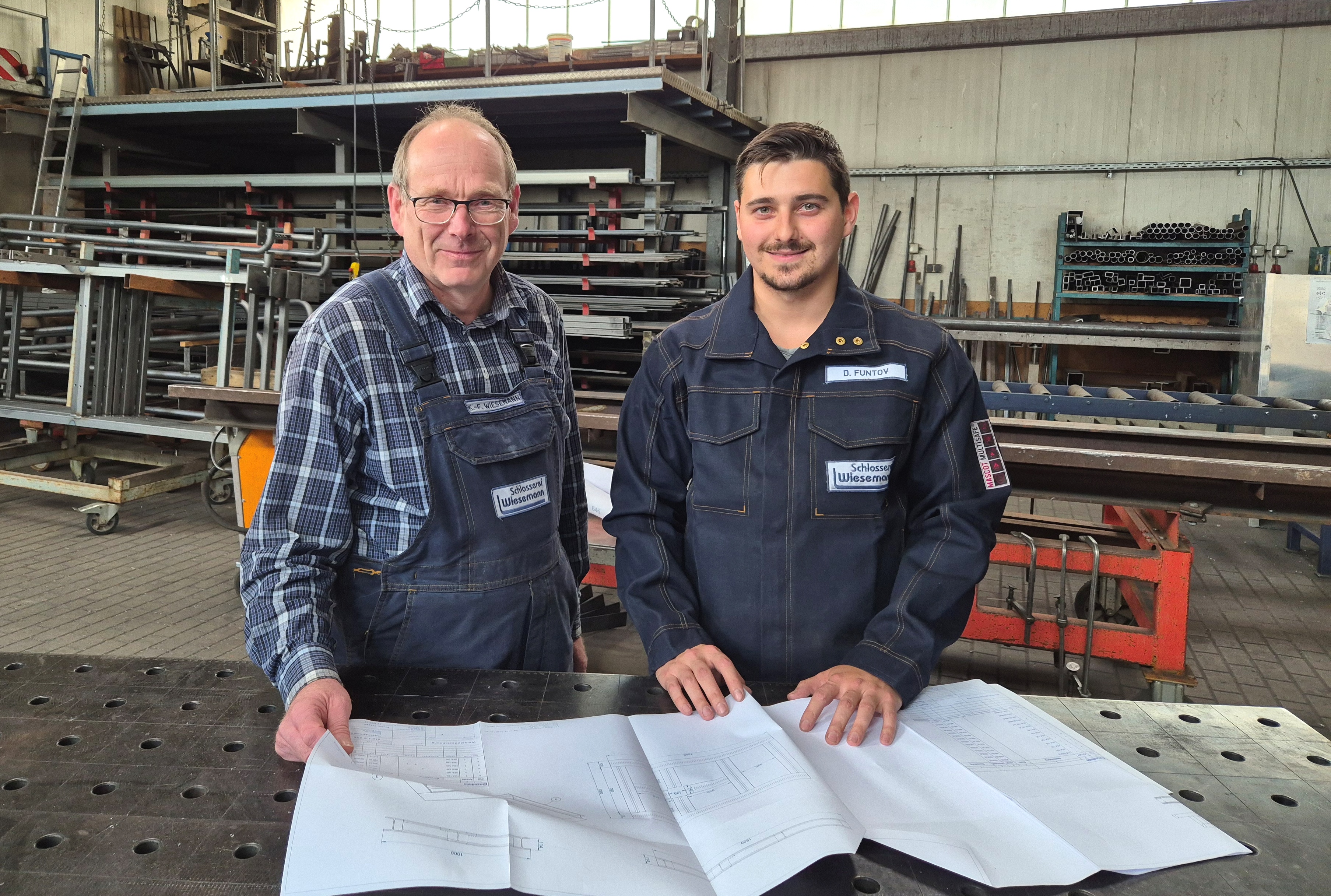 Dmytro Funtov steht mit Firmenchef Karl-Friedrich Wiesemann in der Werkstatt der Schlosserei Wiesemann.